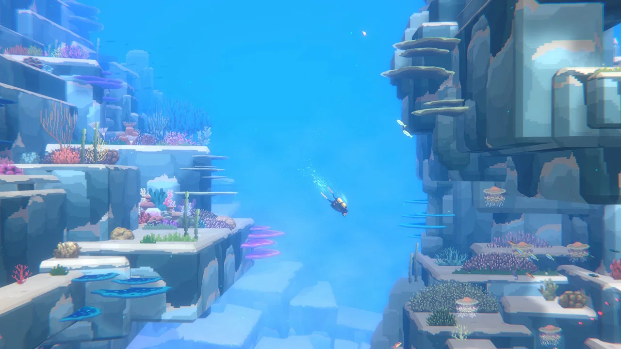 Diver Dave descending into deep ocean waters between coral-covered sea cliffs