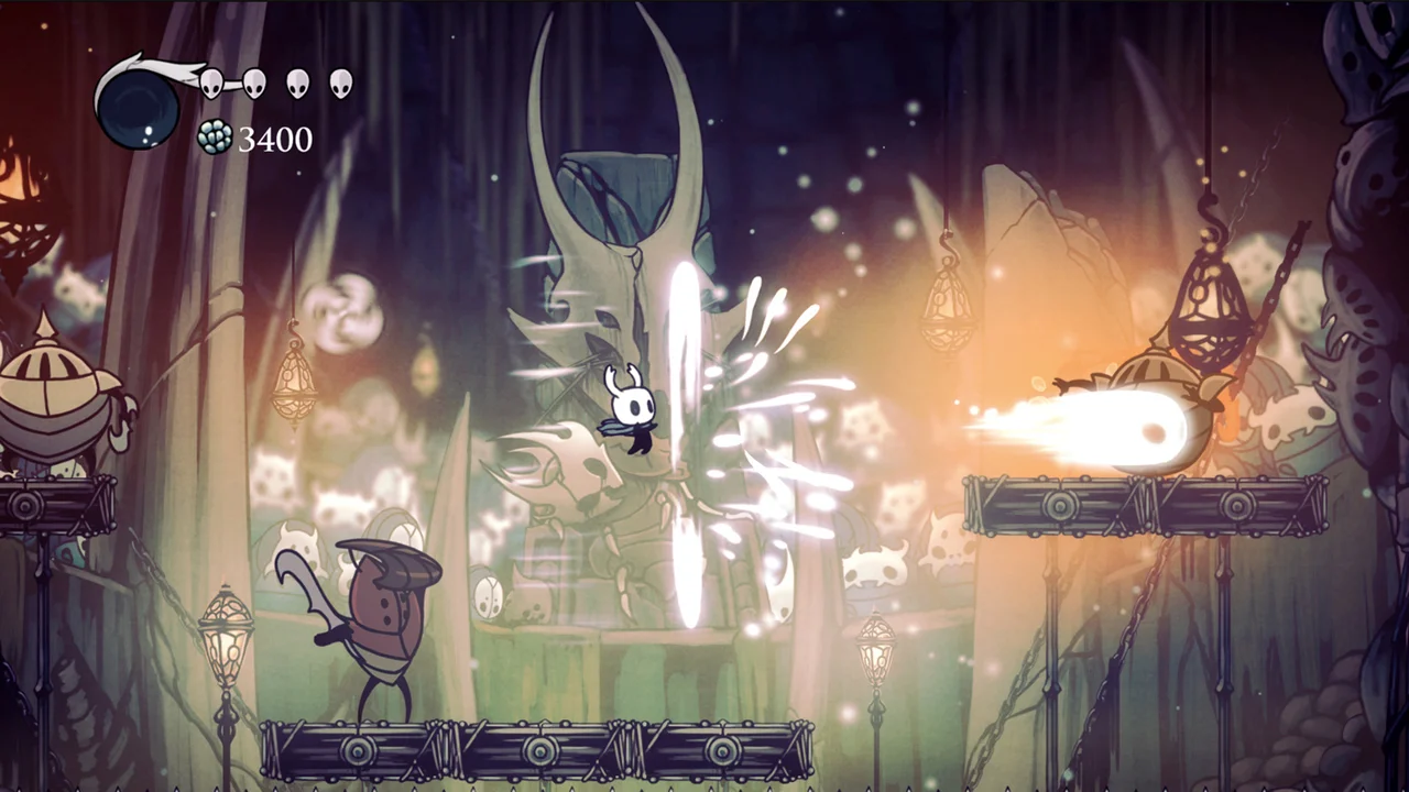 The small Knight character swinging a nail upward in a subterranean arena surrounded by armored insect warriors
