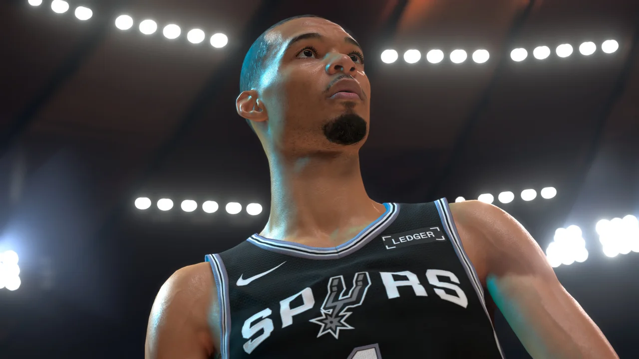 Gameplay screenshot of NBA 2K27 showing pro basketball court action, player drive to the rim, and packed arena crowd
